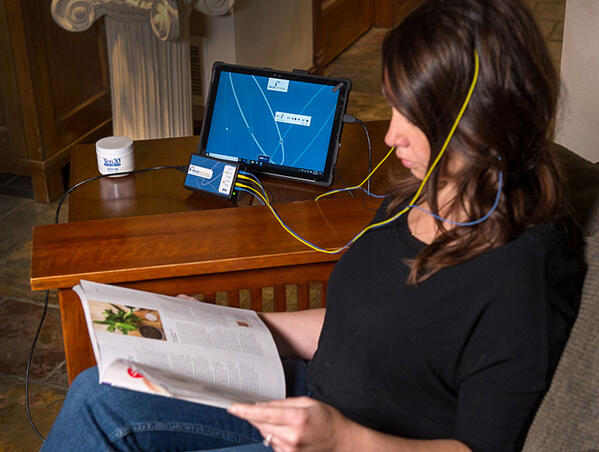 woman reading while doing neurofeedback at home